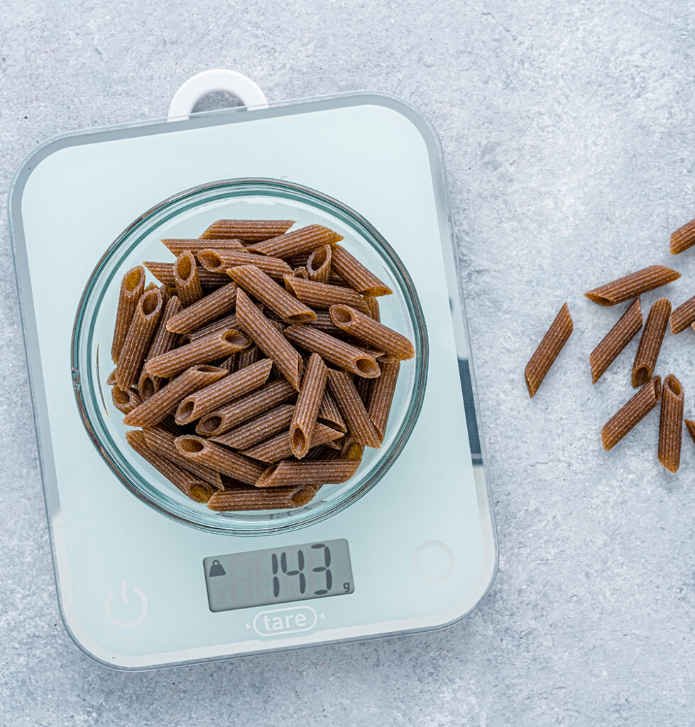 A scale for food weighing a bowl of chocolate noodles.
