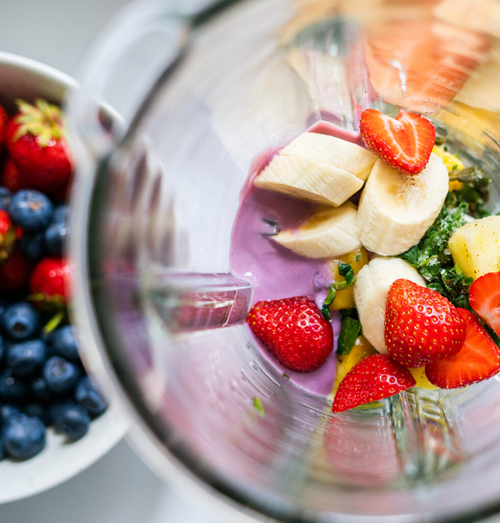 A clear bowl with fruit and yogurt to make a smoothie.
