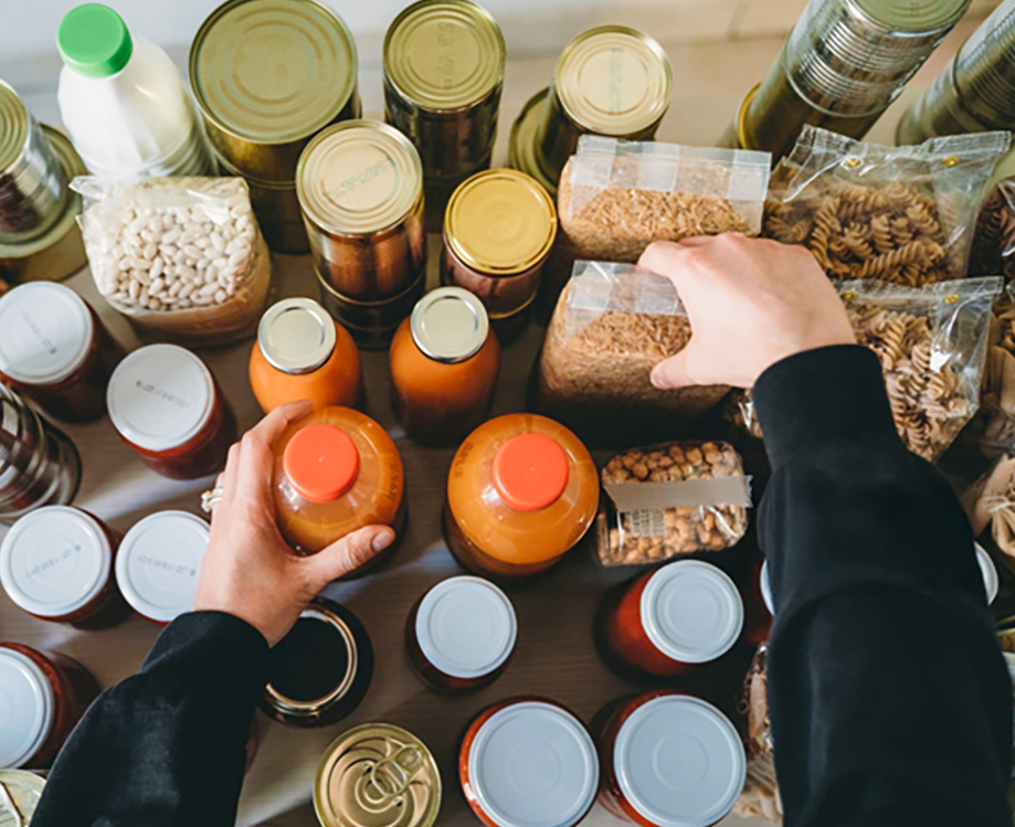 A top down photo of hands organizing canned goods.