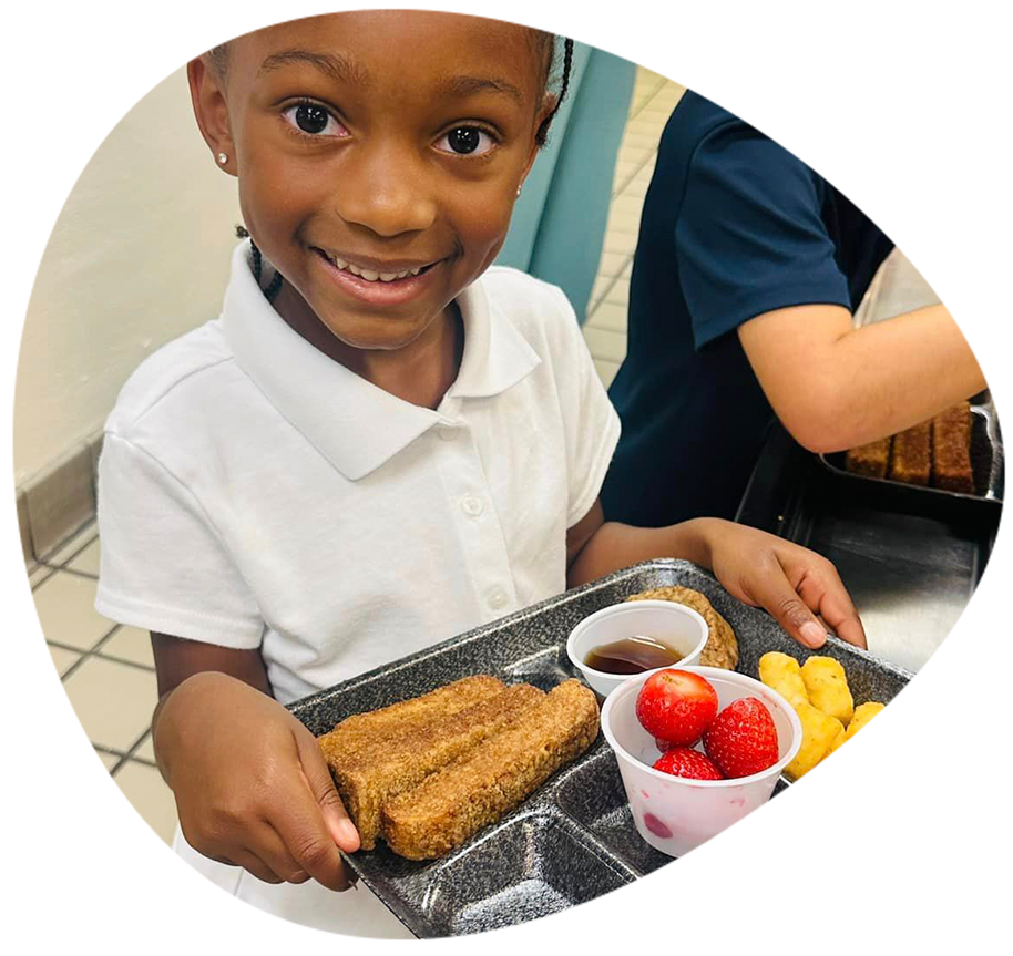 A photo of an African American boy holding a tray of food.