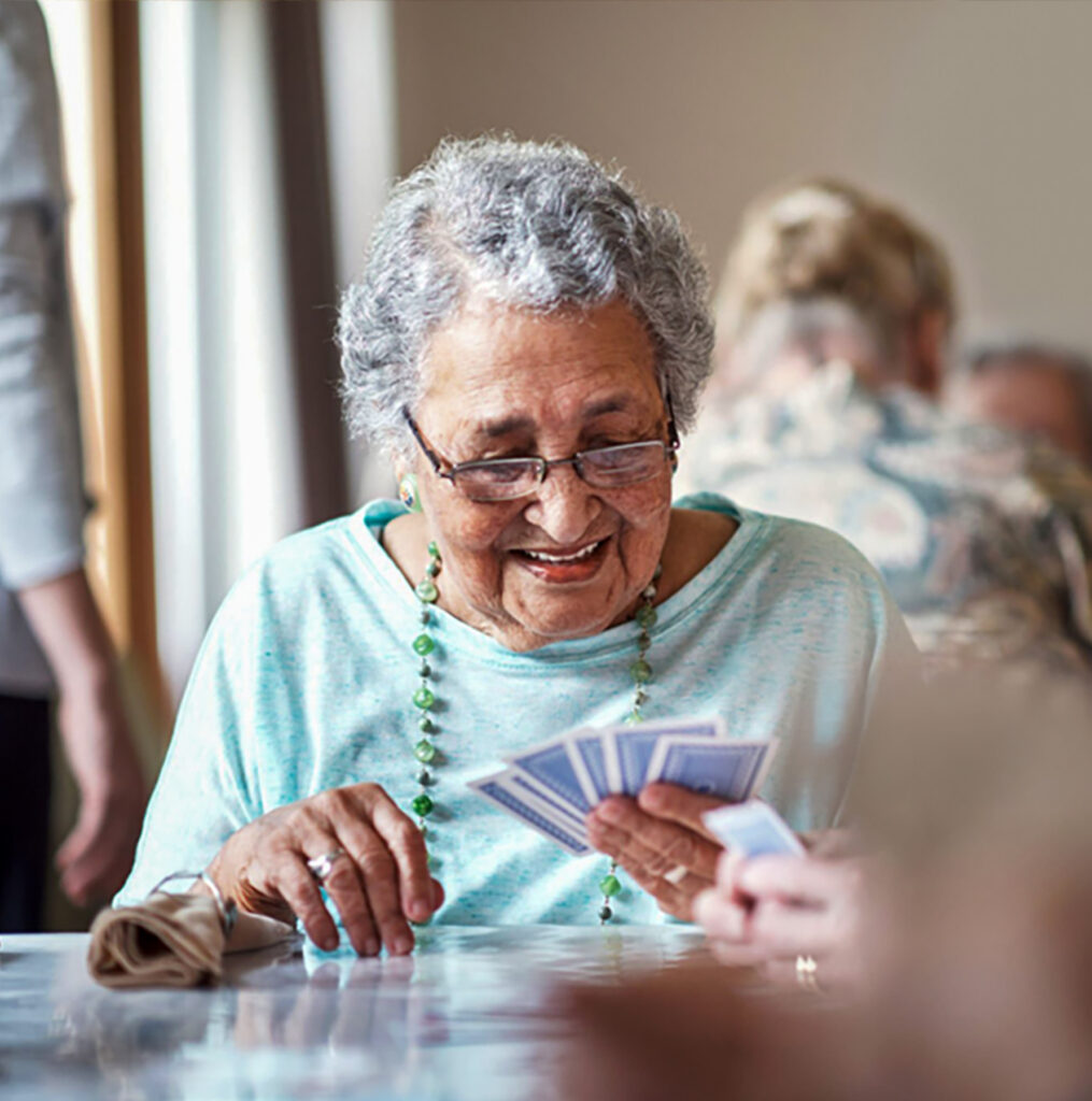 An older woman playing cards.