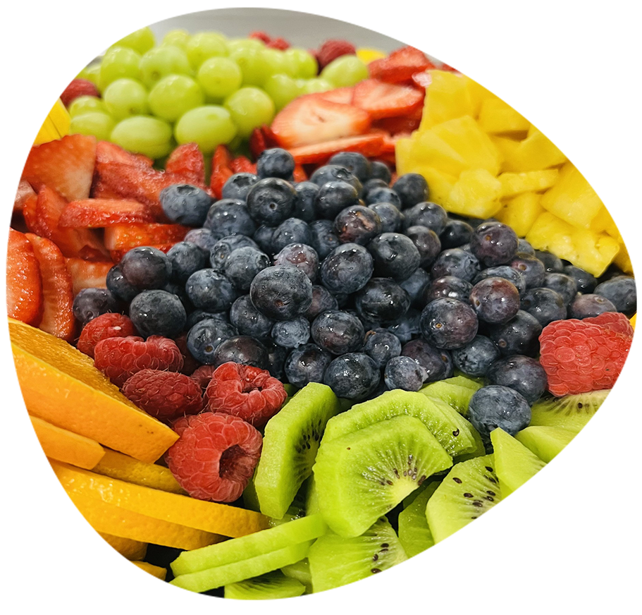 A close up shot of a fruit salad with blueberries, kiwi, strawberries and more.