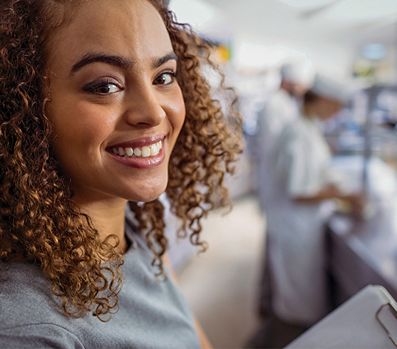 An African American female chef working in a kitchen.
